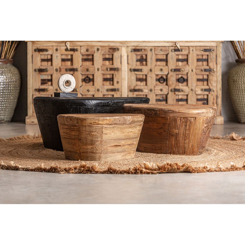 Tavolino basso di design in teak massello con forme scultoree e finitura naturale in ambientazione etnica chic.